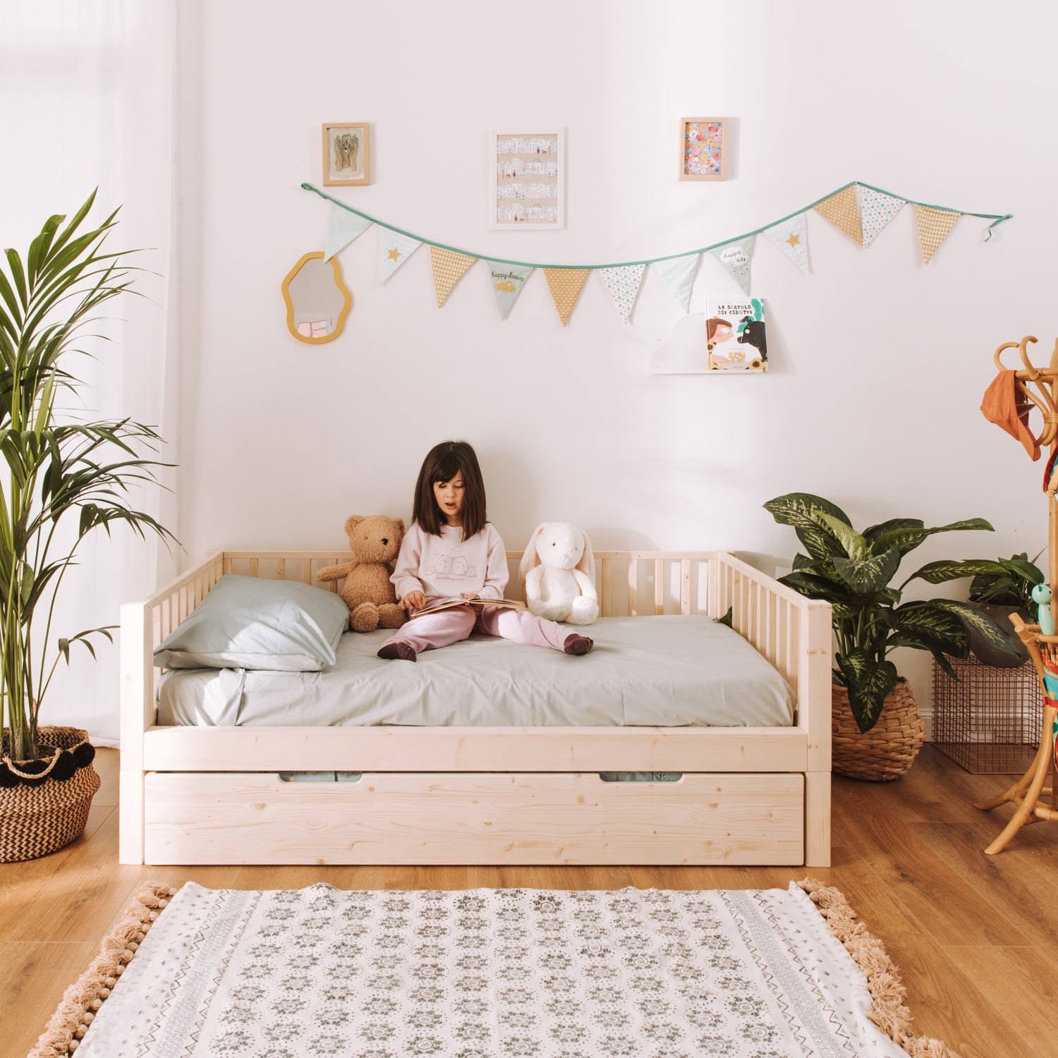 bambina seduta su letto montessoriano zero+ earth con cassettone estraibile
