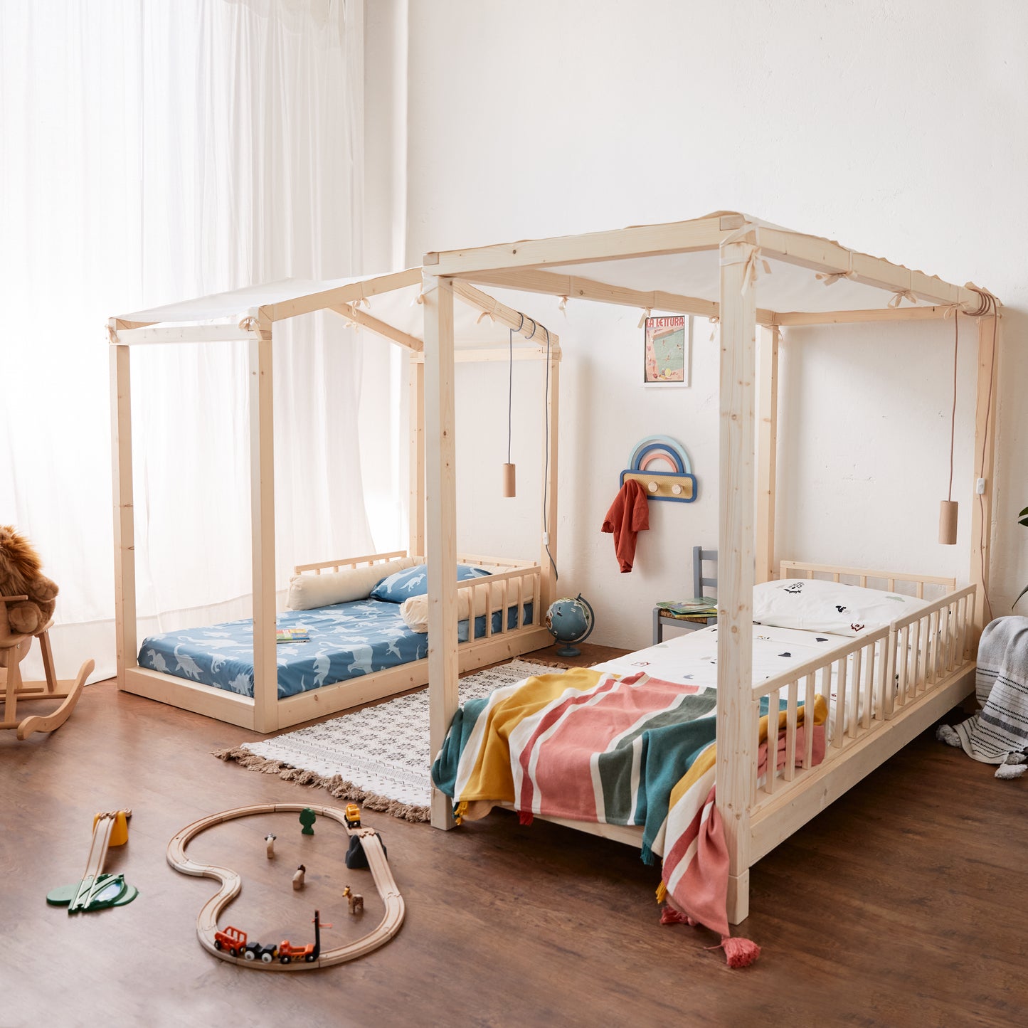 cameretta con due letti montessori con baldacchino in legno coperto con telo colore naturale