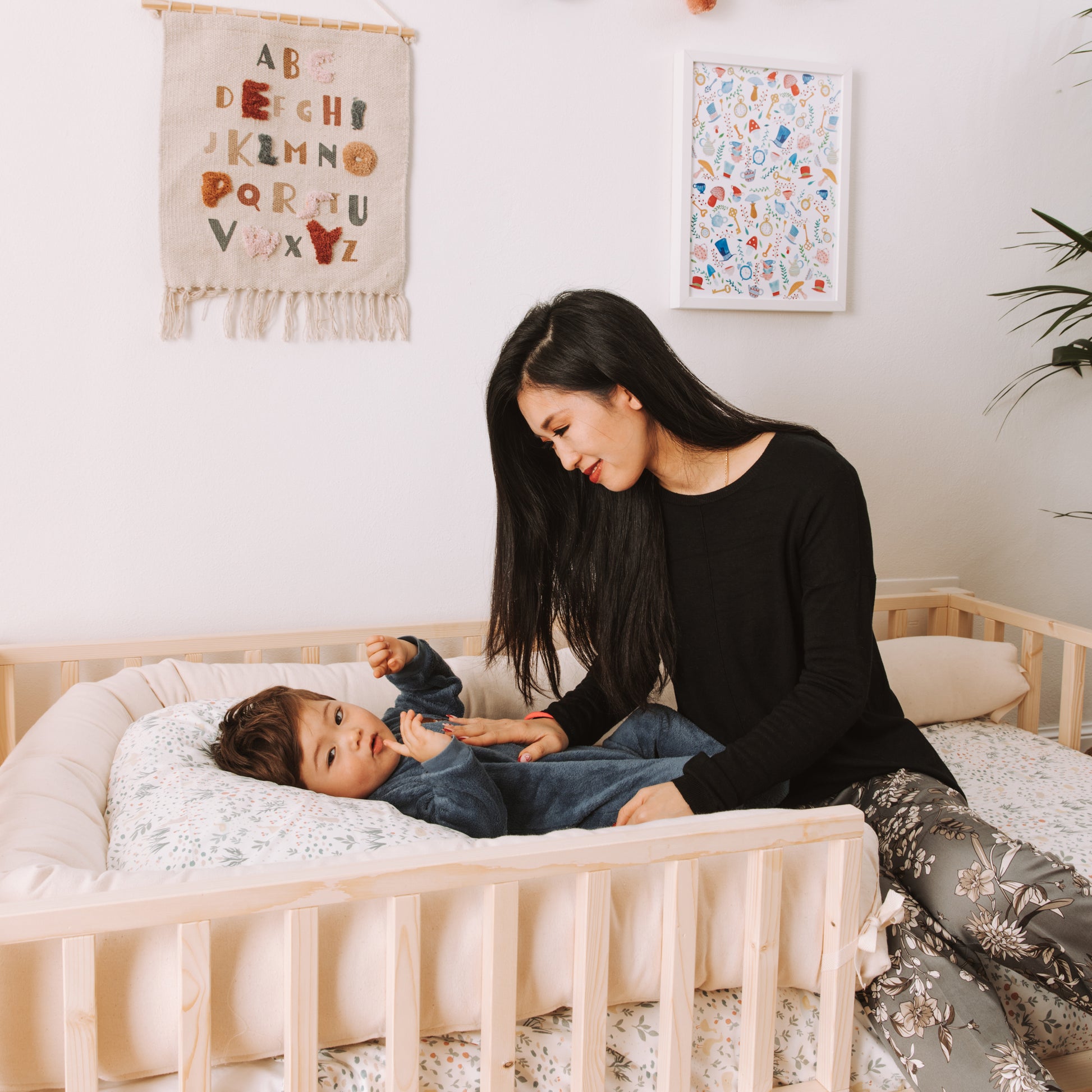 mamma e bambino su letto montessoriano zero+ dream con barriere e cuscino paracolpi