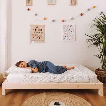 bambina dorme su letto in legno naturale dal design minimale made in Italy