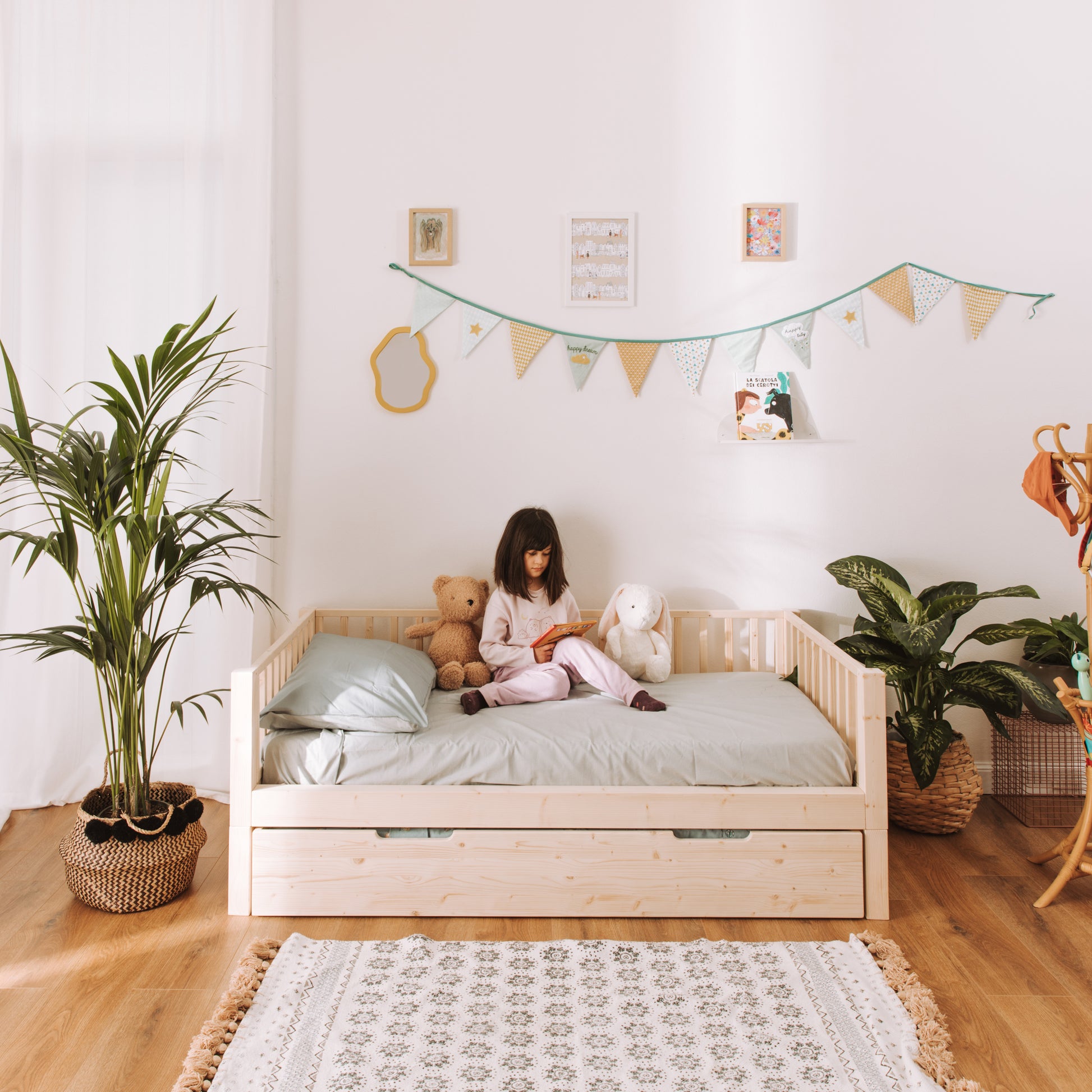 bambina legge sul suo letto montessoriano zero+ earth con cassettone estraibile